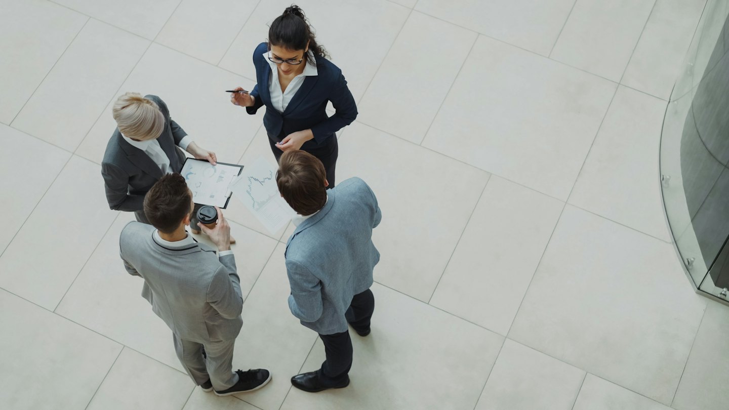 Professionisti aziendali che collaborano su grafici in un ufficio moderno.